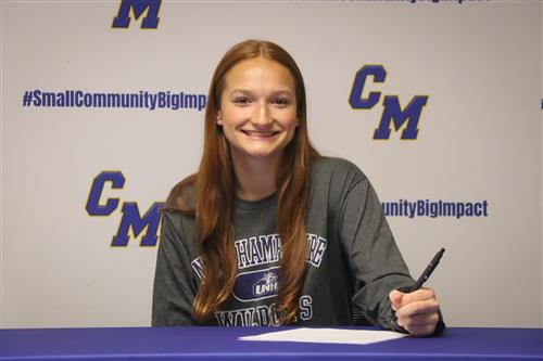 Amber Clarke smiles as she signs