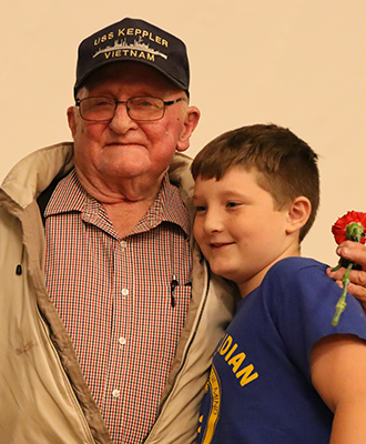 Photo of a Cato-Meridian student standing next to their Veteran
