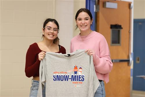 Students hold a gray t-shirt from the American Red Cross