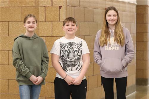 Sixth grade students pose in the hallway